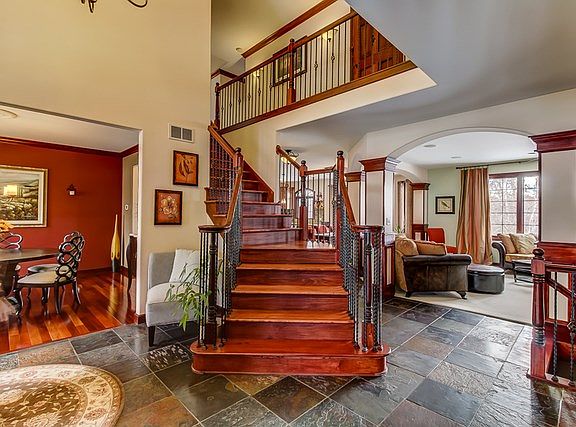 Two story entrance foyer, slate tile and custom staircase.