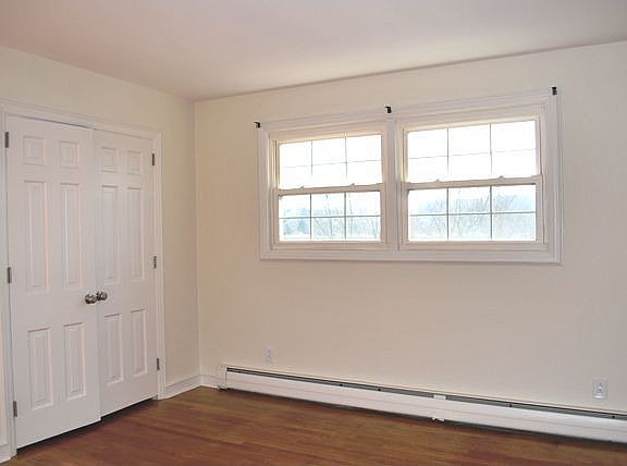 First bedroom with hardwood floors and big closet