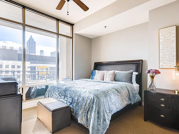 The bedroom offers floor-to-ceiling windows, a custom walk-in closet, plus an extra smaller closet.