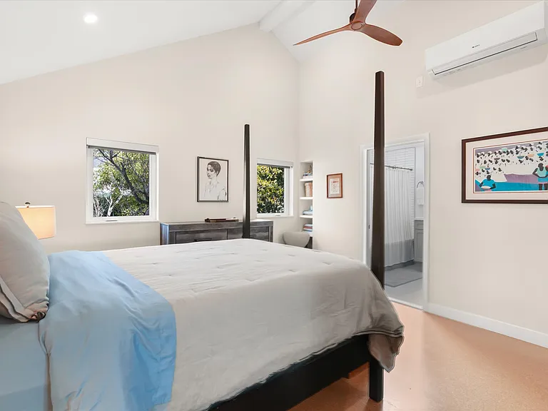 Spacious bedroom with vaulted ceiling and natural light.