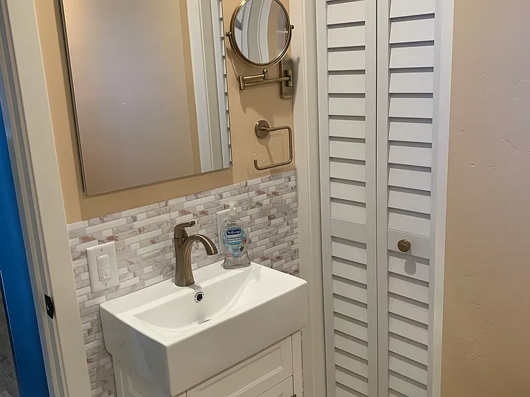 Bathroom sink, lighted mirror cabinet and magnified mirror