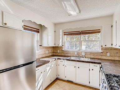 Kitchen with gas range, sink at window, stainless appliances.