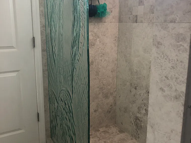Newly renovated Italian tile and marble shower with permanent glass etched palm tree attached