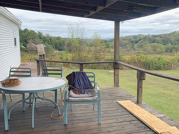 Back of house with covered deck. Table and chairs can stay.