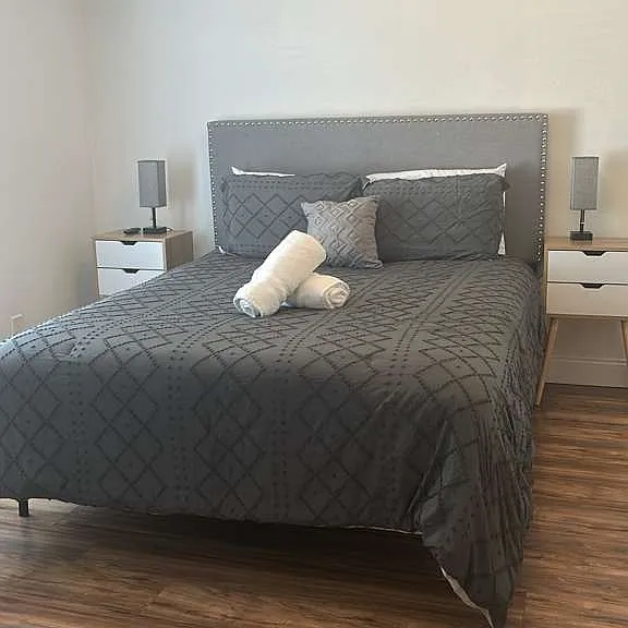 Charming queen room with elegant lamps, nightstands, and cool AC.