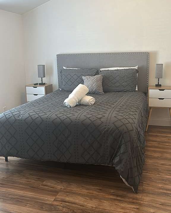 Charming queen room with elegant lamps, nightstands, and cool AC.
