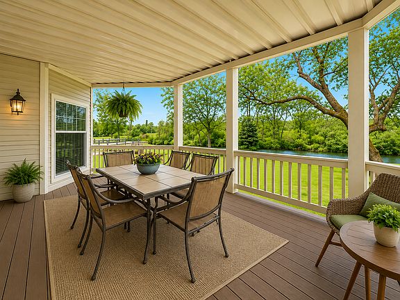 Relax and unwind on the spacious covered deck overlooking lush green space and tranquil water views. Perfect for morning coffee, outdoor dining, or entertaining guests while enjoying the peaceful natural setting.