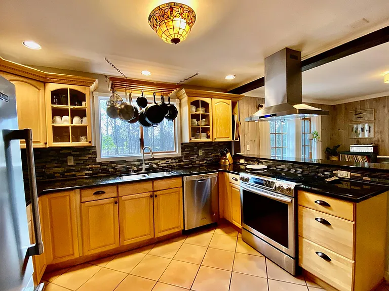 Stainless steel appliances, double sink, swaths of granite counter space, walk in pantry, stow away garbage, and more.