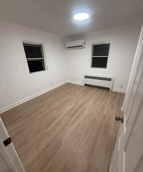 Bright bedroom with two windows, mini split and closet