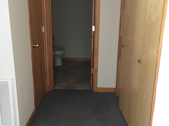 Hallway with linen closet and bathroom, plus washer/dryer connections behind bi-fold doors.