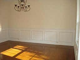 Separate dining room has hardwood, wainscoting, and wrought iron chandelier