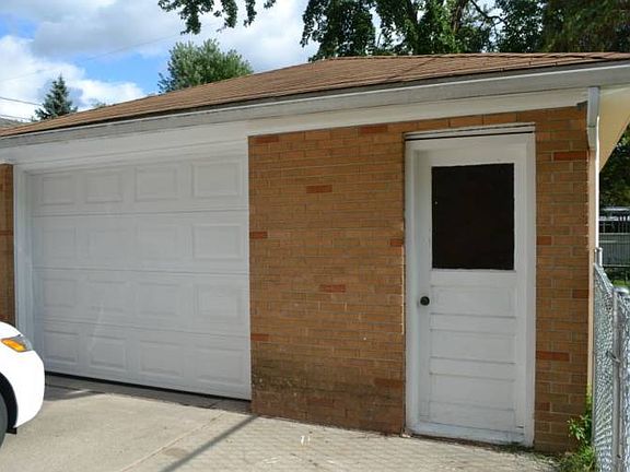 The 1.5 car detached garage features a new door plus an extra access door to one side.  The driveway is concrete and the fence enclosing the backyard also runs between the garage and the back of the home. 