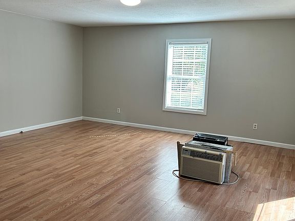 Huge living room with hardwood floors and wood blinds.