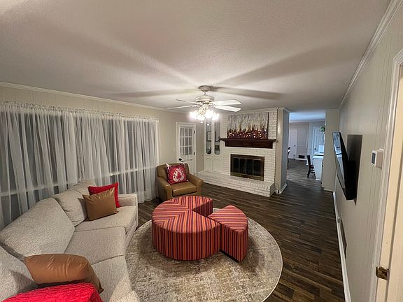 Family room/den, has ample seating w/ultra comfortable curved chenille sectional & round oversized nap sized ottoman or sit alone in the large leather chair. Lamp & end table w/ Wi-Fi smart tv set up 500+ channels. Gas fireplace & back deck access.