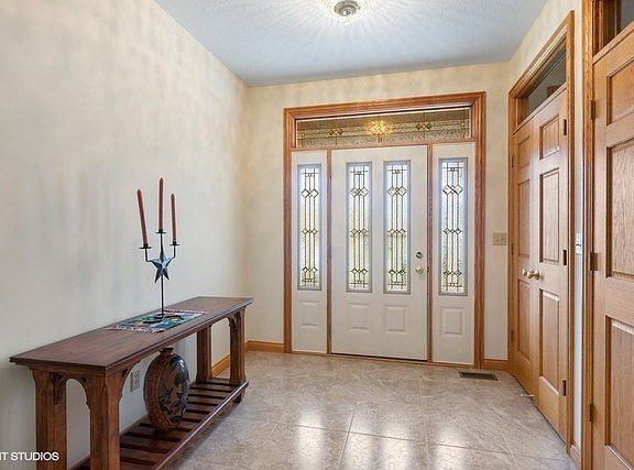 Beautiful foyer enhanced with ceramic tile, decorative front door and sidelights with transom.  Plus