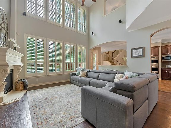 Natural light fills the family room with two story ceiling and plantation shutters. Open to Kitchen and breakfast bar. Mounted speakers for surround sound remain with the home.