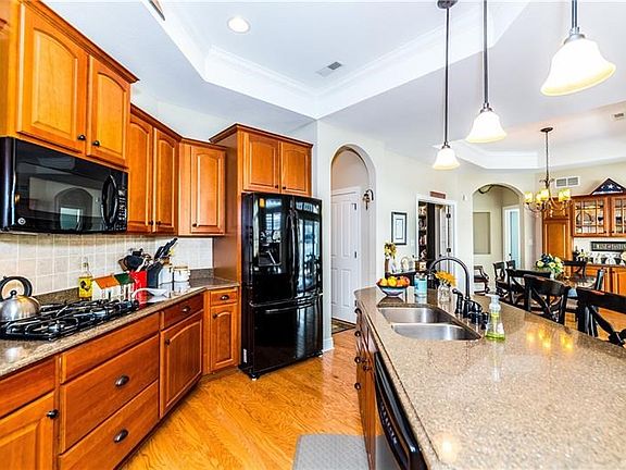 Double stainless sink and pendent lights over the granite island... the kitchen is open to the dining area for easy  entertainme
