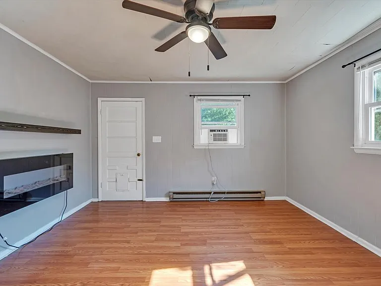 Den w/ Electric Wall Fireplace and Mantle! Blinds Provided by Landlord! NEW Black Matte Curtain Rods Installed by Landlord!