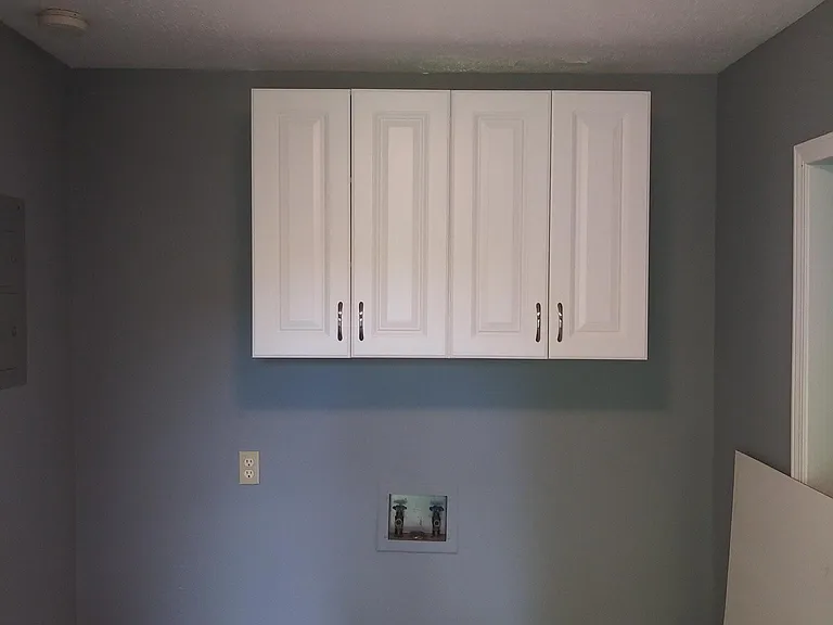 Large utility room with cabinets and washer & Dryer hook ups.