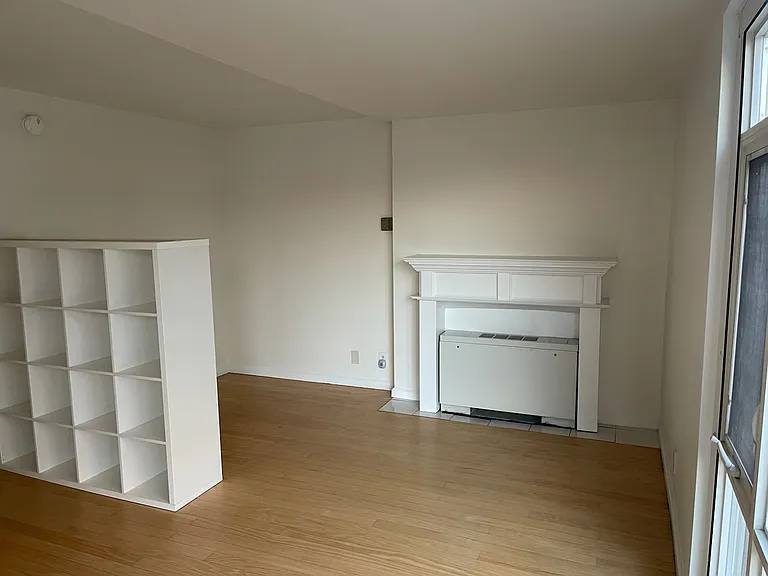 Separate sleeping alcove with decorative fireplace mantel. Flexible room divider for books or display