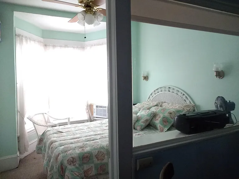Bedroom off dining room area has shade on window and blind on door for privacy.