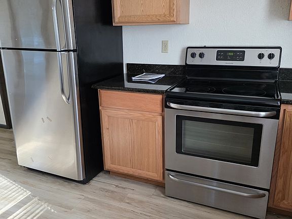stainless steel frig and stove with granite countertops
