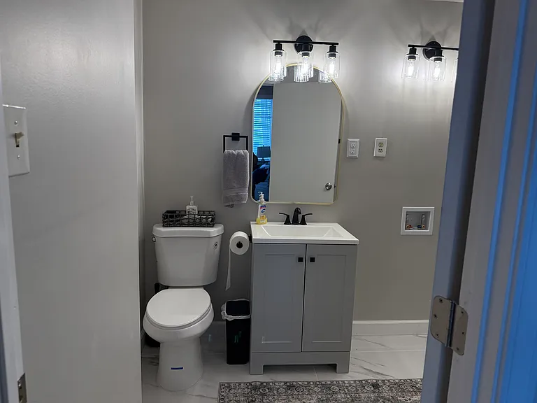 This updated full bathroom offers a fresh, modern look with a stylish vanity, contemporary lighting, updated fixtures, and sleek finishes throughout.