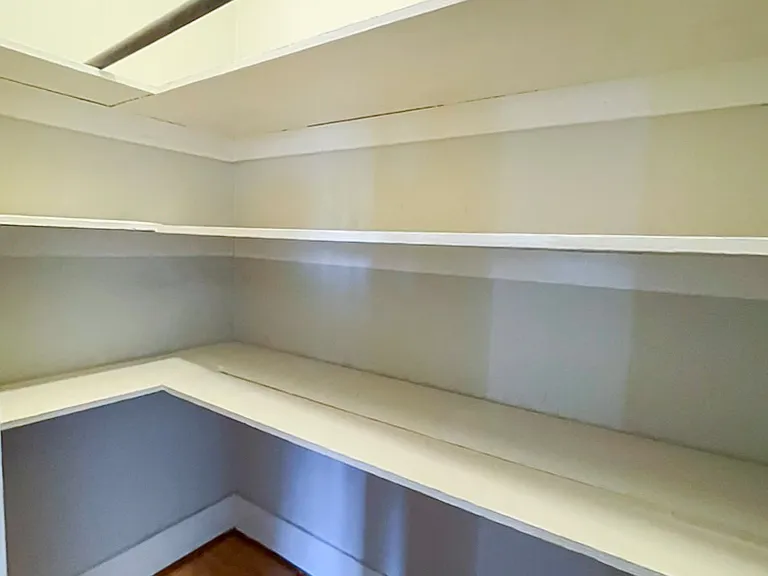 Large hall closet with sliding, wooden doors.