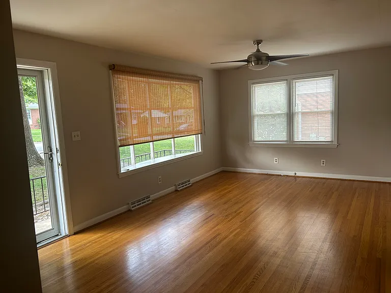 Large living room, plenty of natural light, new blinds, bay window, 70 year old original hardwood flooring