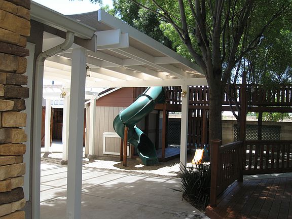 Back yard area, partial view of children's play structure wi