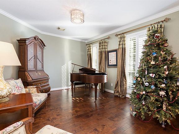 A relaxing formal living space offers a place to sit and enjoy an evening glass of wine! Additional touches such as crown molding, Plantation shutters and classy light fixtures completes the space!