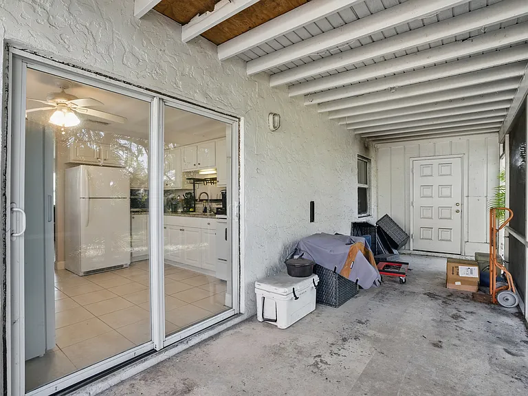 The screened lanai offers a peaceful outdoor retreat with views of the spacious backyard, perfect for morning coffee, evening relaxation, or enjoying the Florida breeze bug-free