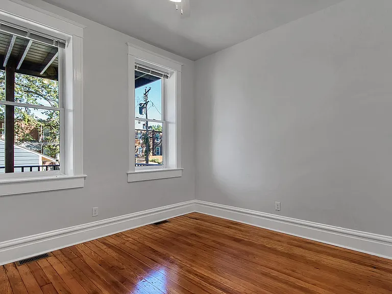 Bedroom 1 - salvaged hardwood floors, ceiling fan, large closet, venetian blinds