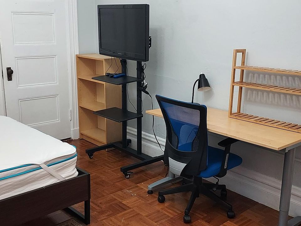 Fully furnished bedroom includes double bed, desk and chair, and loveseat with a coffee table.