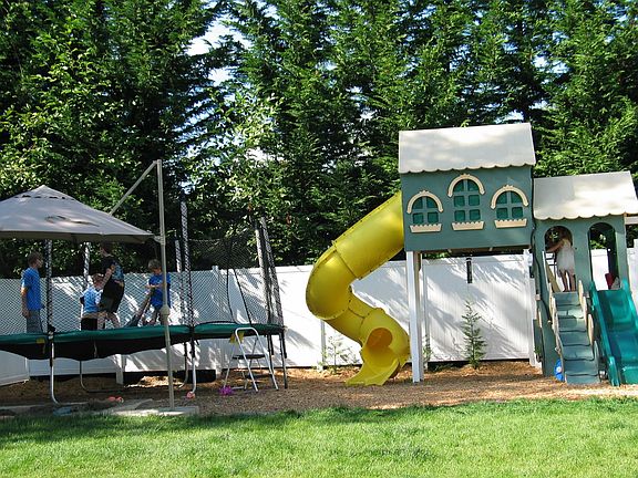 Greenbelt in back of 6ft vinyl fence, huge playset and built in sandbox.