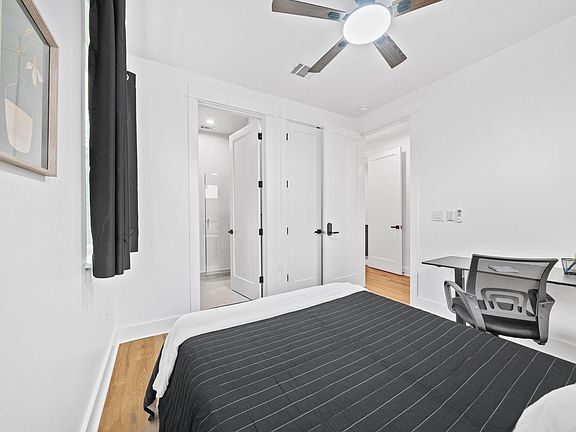 Bedroom features a ceiling fan, dedicated desk workspace, and closet storage with convenient access to an adjacent bath.