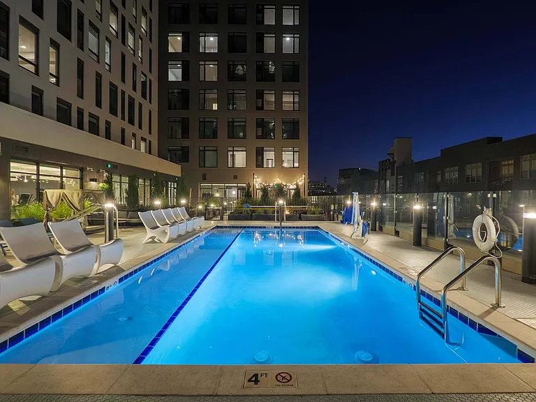 Enjoy the calm of the nighttime pool, with glowing lights reflecting on the water.