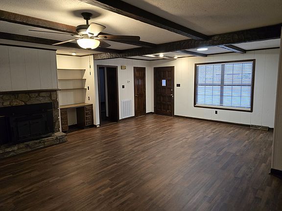 Living Room w/ fireplace, built-in shelving & sliding door to back yard.