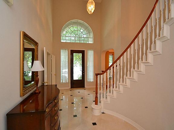 Elegant entry offering a beveled glass front door accented by marble tile floors, double crown moldi