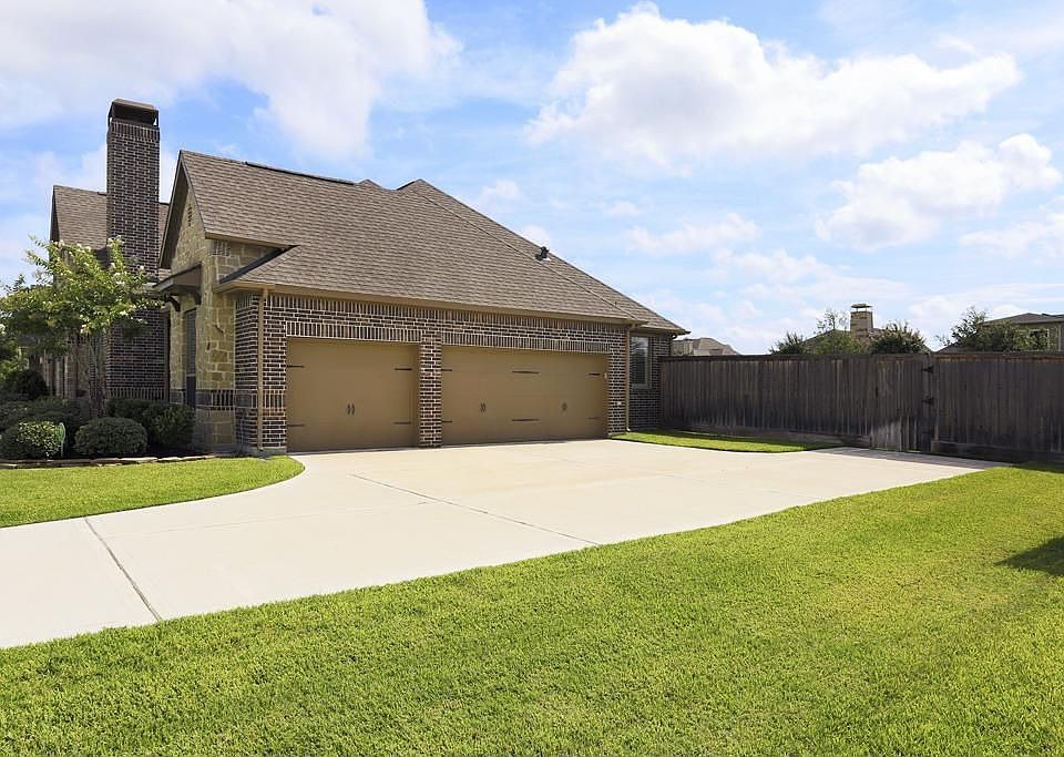 Three car side entry garage with garage door openers. Architectural metal detail on the garage doors.Added concrete drive area for convenience.  Room finish on garage walls.