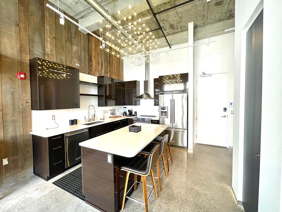 Well appointed Kitchen Aid appliances, gorgeous overhead light, 3 barstools, wood panel throughout . Chalkboard accordion door for your pantry to the right of the kitchen.