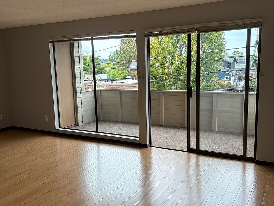 Living room, looking out sliding door to large balcony which overlooks Tangletown neighborhood