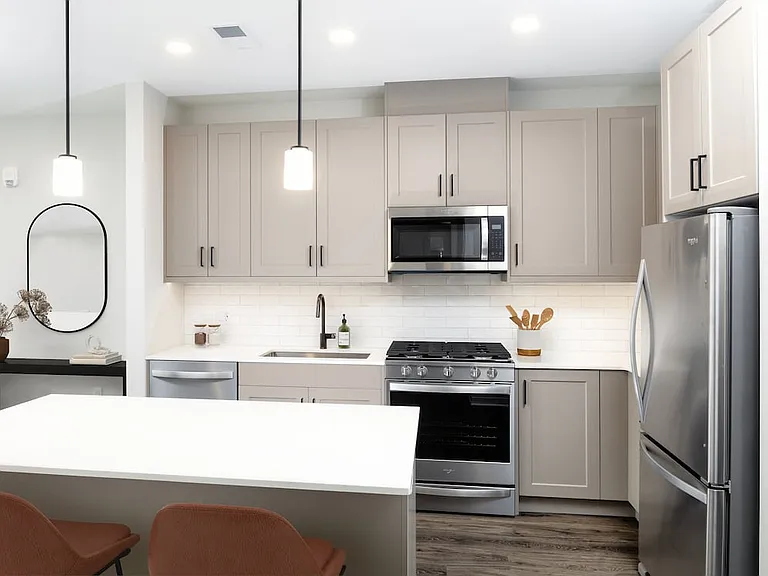 Upgrade Collection kitchen with stainless steel appliances, quartz countertops, tile backsplash, grey cabinetry, and hard-surface flooring