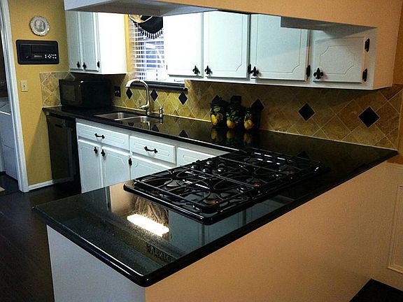 Another view of the kitchen with its custom tile backsplash and five-burner gas cooktop...