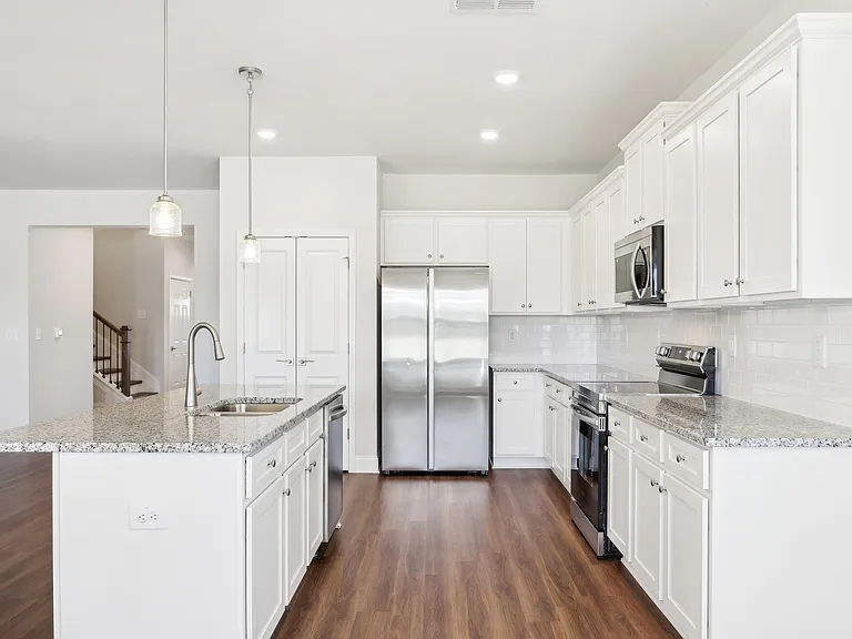Modern kitchen featuring white cabinets and granite countertops.