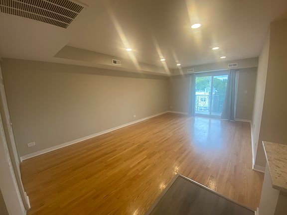 Living area. Open space to kitchen. Balcony off living area with sliding door.