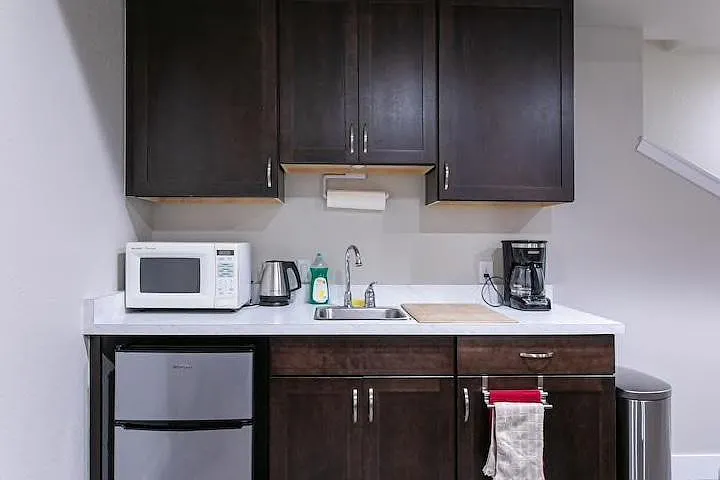 Downstairs wet bar with sink, refrigerator with freezer compartment