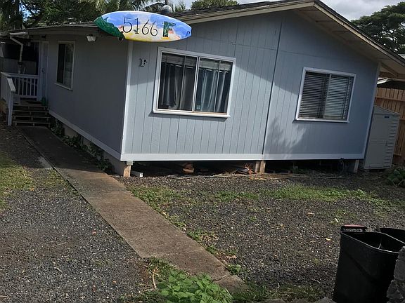 Street view of home with gravel parking