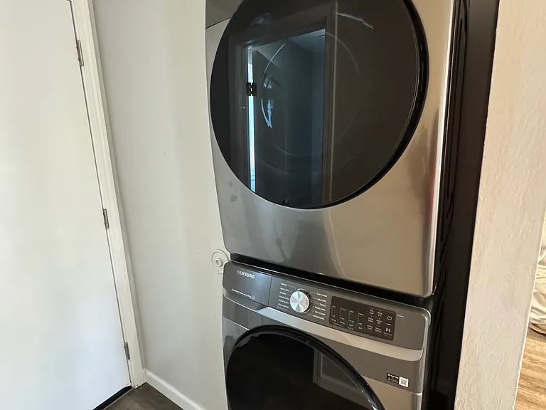 New Samsung stacked full-sized washer and dryer are included in the unit.