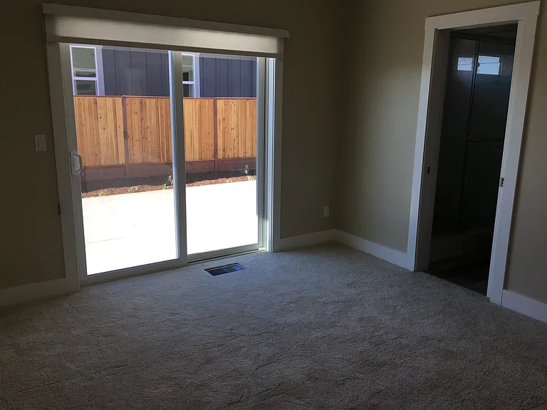 Master bedroom with sliding glass door to the backyard.